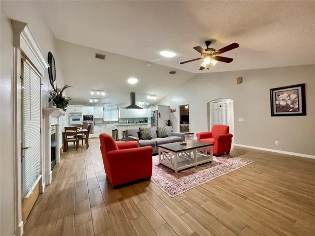 A broad view showcases the spacious main living area and its seamless connection to the kitchen, with skylights offering an abundance of natural light and plenty of room for multiple seating arrangements.