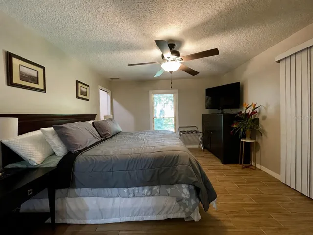 Generously sized primary bedroom features a ceiling fan, natural light, neutral finishes, and ample space for additional furniture.