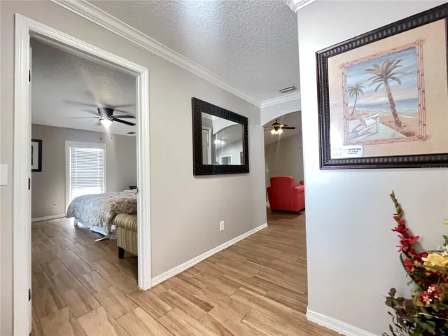 The entry opens to a neutral interior with crown molding, arched architectural details, and an easy flow toward the main living spaces and bedroom.