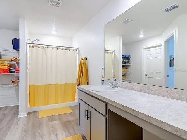 Primary en-suite bathroom/ walk in shower- extended vanity - walk in closet - open linen area