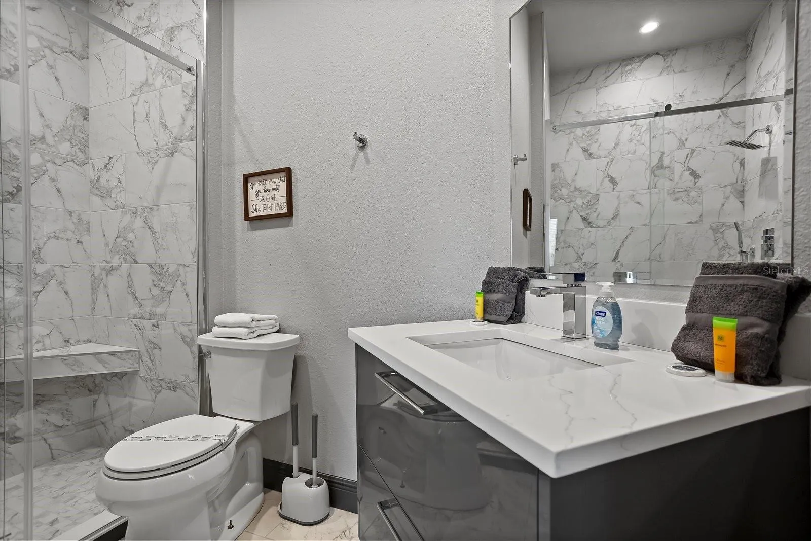Beautifully renovated primary bathroom with floating vanity and quartz countertop