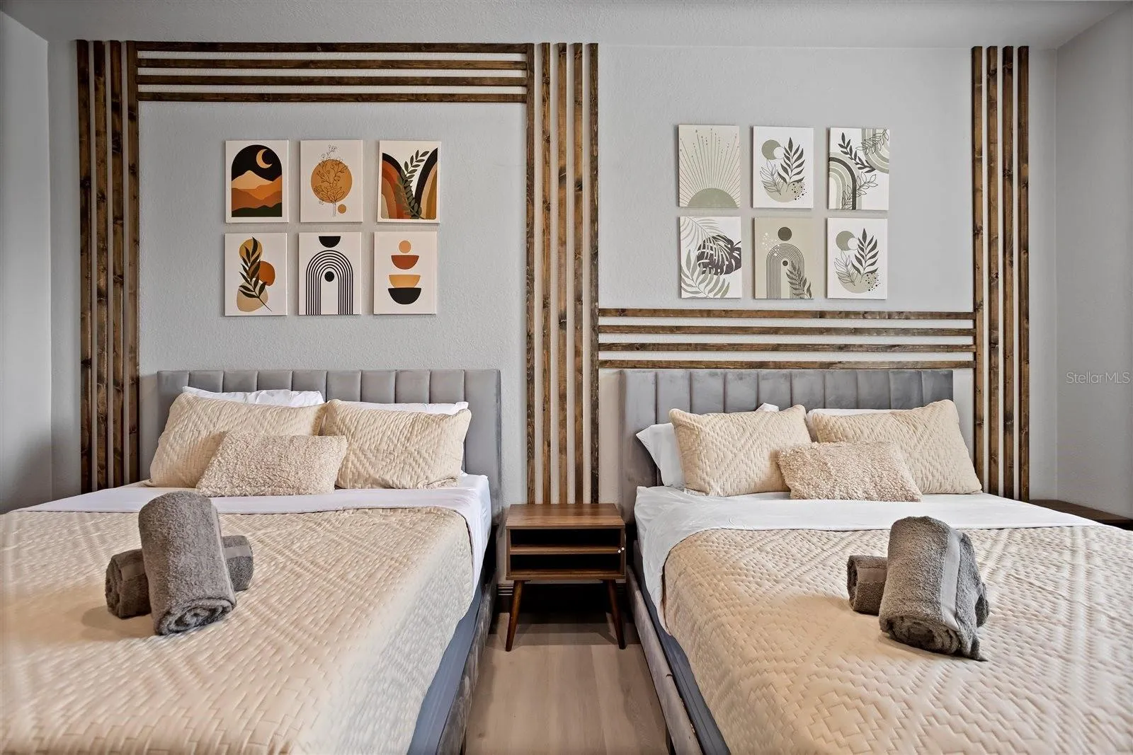 Spacious second bedroom with two beds and custom decorative accent wall