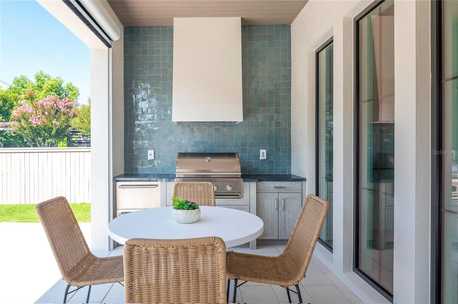 Summer Kitchen with 32" grill, dual beverage drawers, Naturekast weatherproof cabinets, quartz counters & gorgeous tile backdrop