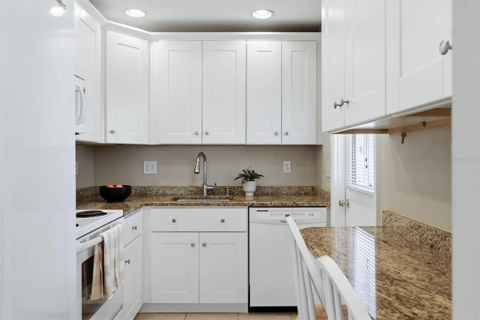 custom kitchen with granite and wood cabinets, as seen from dining room. NOT SHOWN is large (new) refrigerator with ice and water dispenser