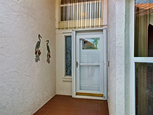 New front door with a storm door and shutters.