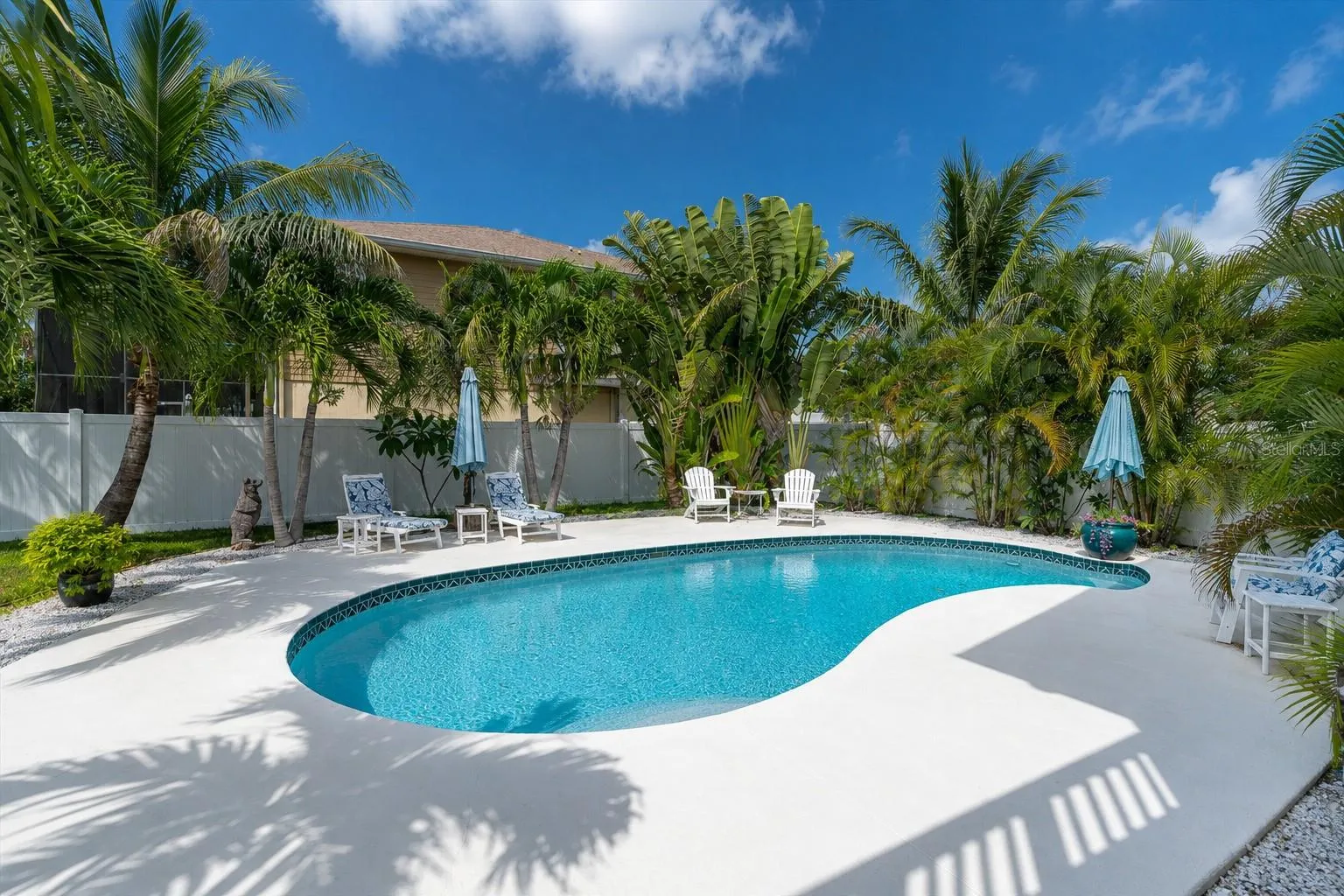 The expansive backyard offers a lush tropical setting, fully fenced for privacy &amp; creating a peaceful retreat for relaxing &amp; entertaining.