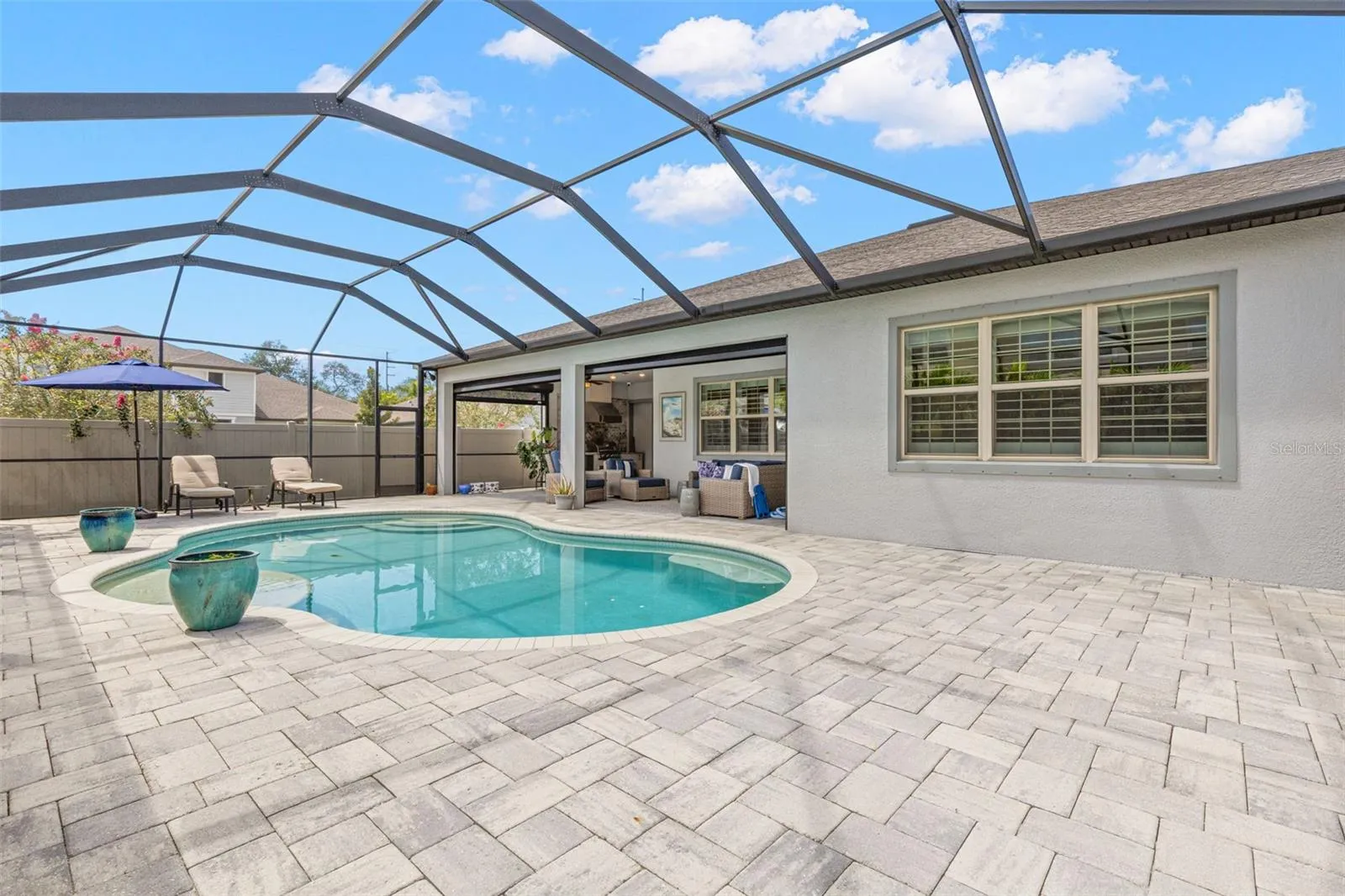A broad brick-paver pool deck creates plenty of room to stretch out around the water, with space for loungers, conversation areas, and sunny afternoons by the pool. The covered lanai sits just steps away, adding shade and an easy transition back to the home.