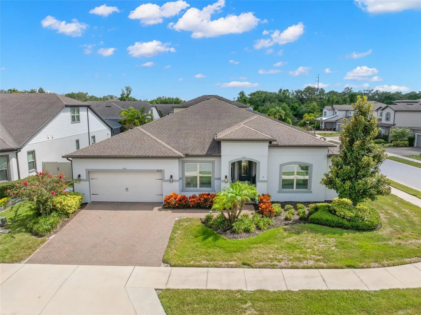 Set on a beautifully landscaped corner lot in the gated Enclave at Palm Harbor, the home’s single-story design, brick-paver driveway, two-car garage and graceful arched entry create a polished sense of arrival from every angle.