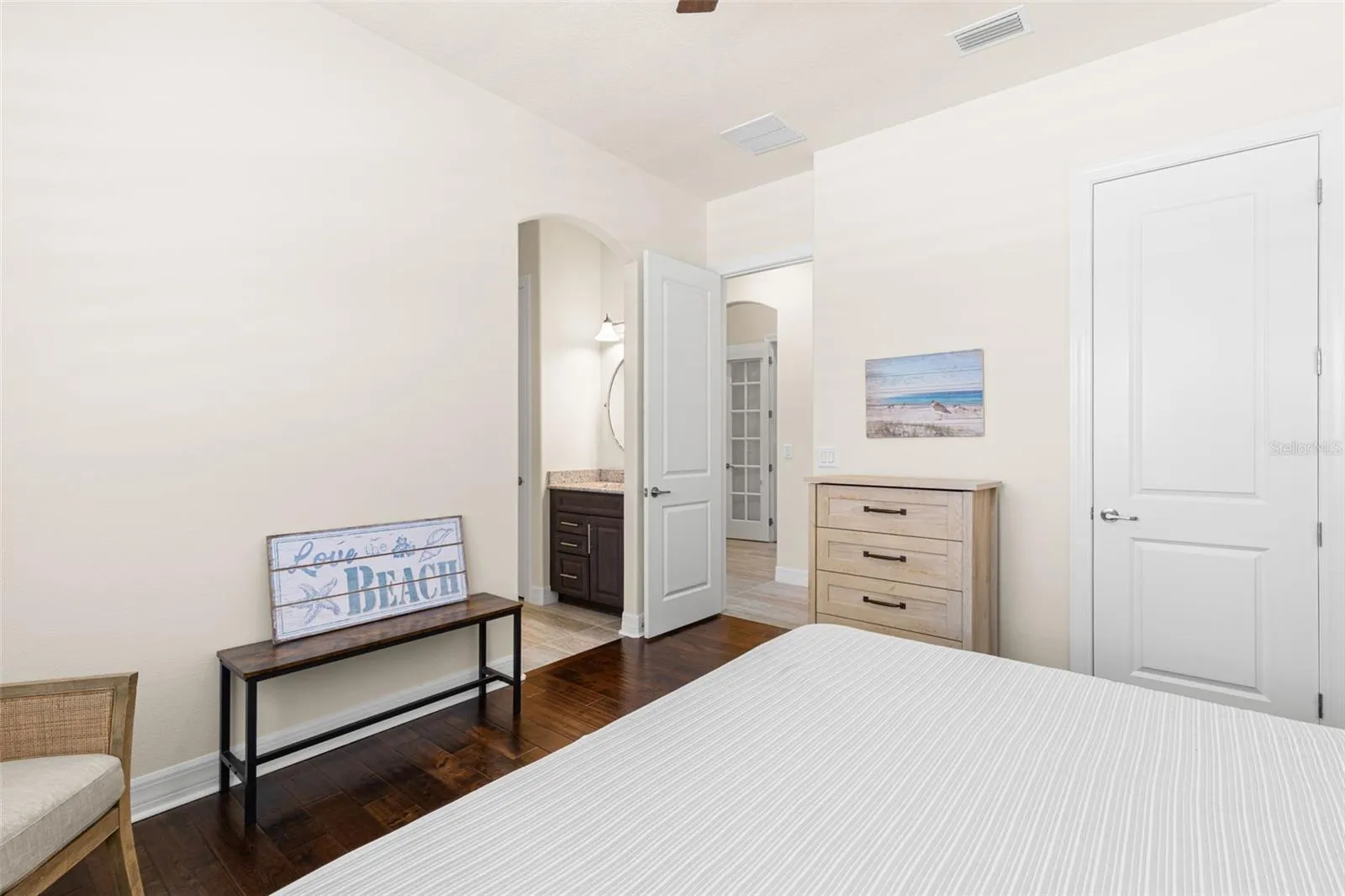 A second view of Bedroom 3 shows its easy connection to the dedicated vanity and shared Jack-and-Jill bath, while a separate closet, engineered hardwood flooring and generous wall space add to the room’s everyday function.