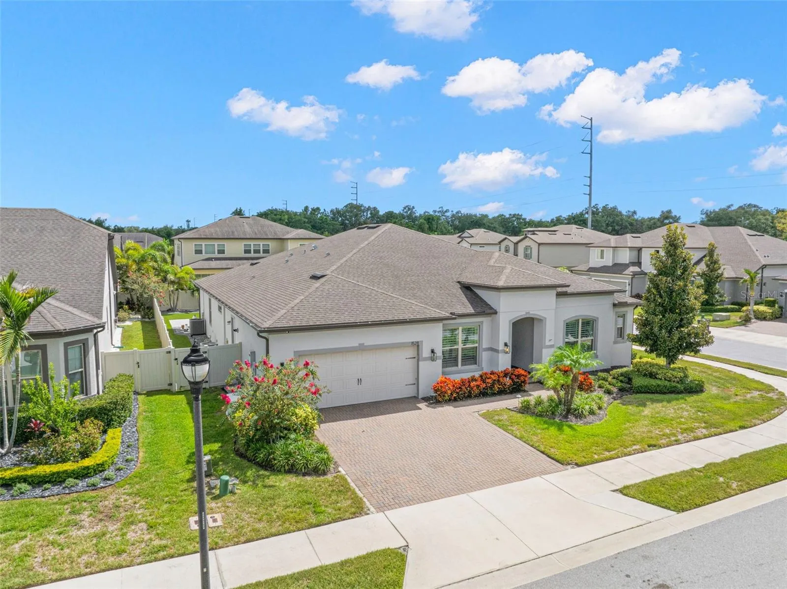 A charming neighborhood streetlamp complements the home’s polished curb appeal, while this elevated view reveals the fenced yard tucked behind the residence — adding privacy and another useful layer to the outdoor living space.