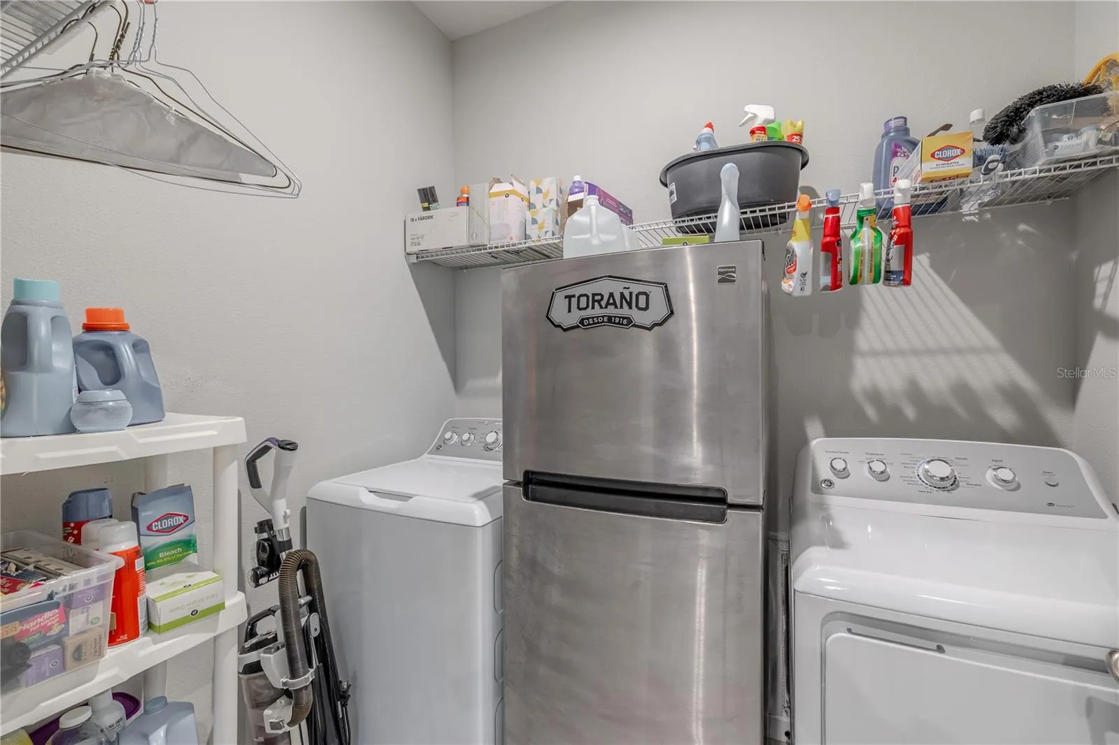The dedicated laundry room offers space for full-size washer and dryer appliances, generous wire shelving and additional storage for everyday household essentials.