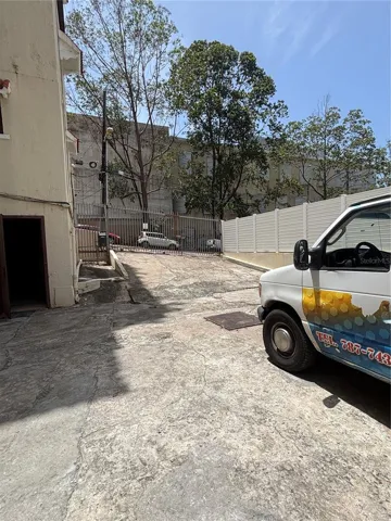 The rear parking/loading area has secure gated access from Calle Cerra. The puerto Rico Conservatory of Music is in the background.  The door at the lower left leads to the additional storage area.