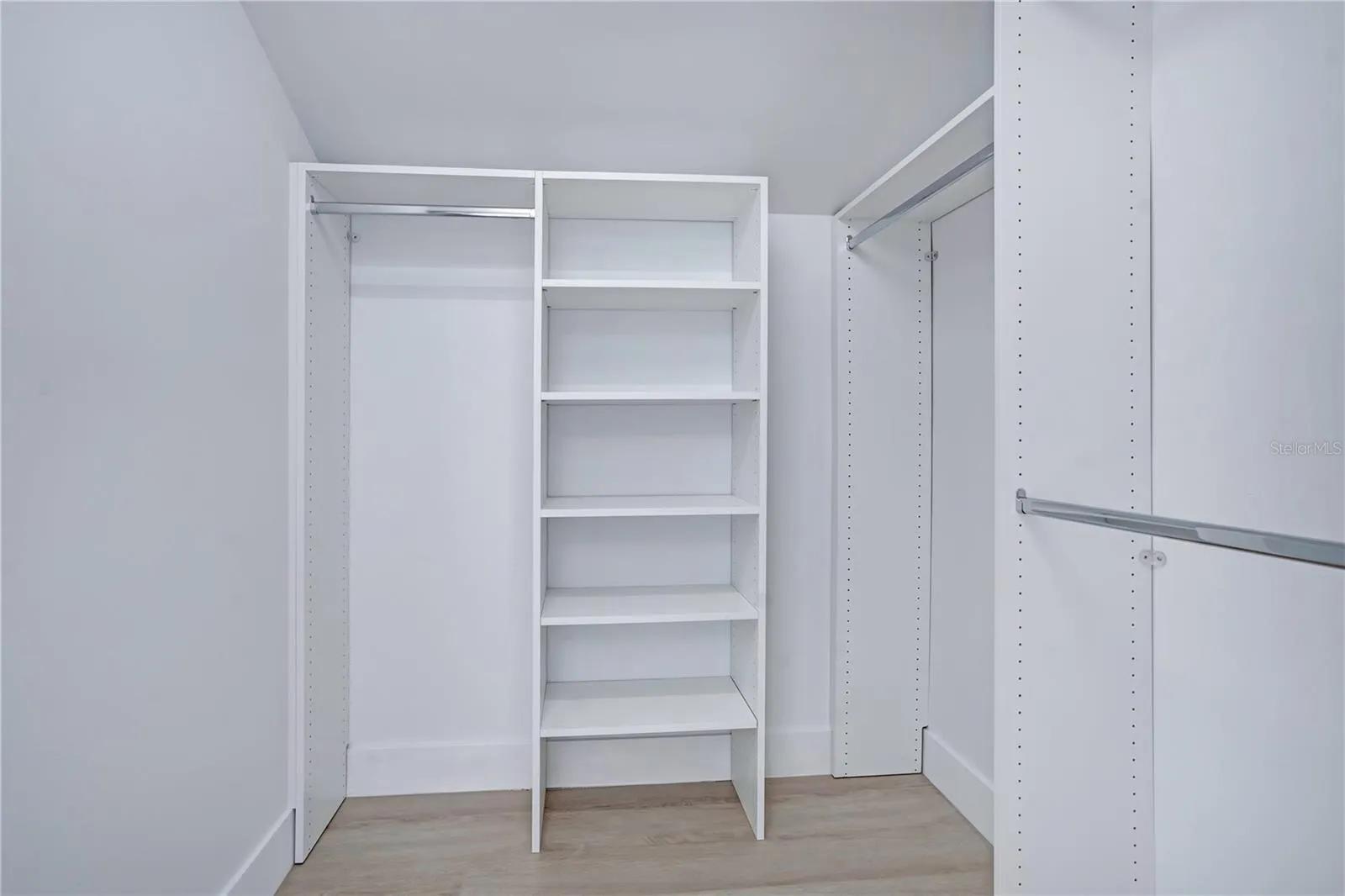 Custom closet featuring built-in shelving and multiple hanging areas.