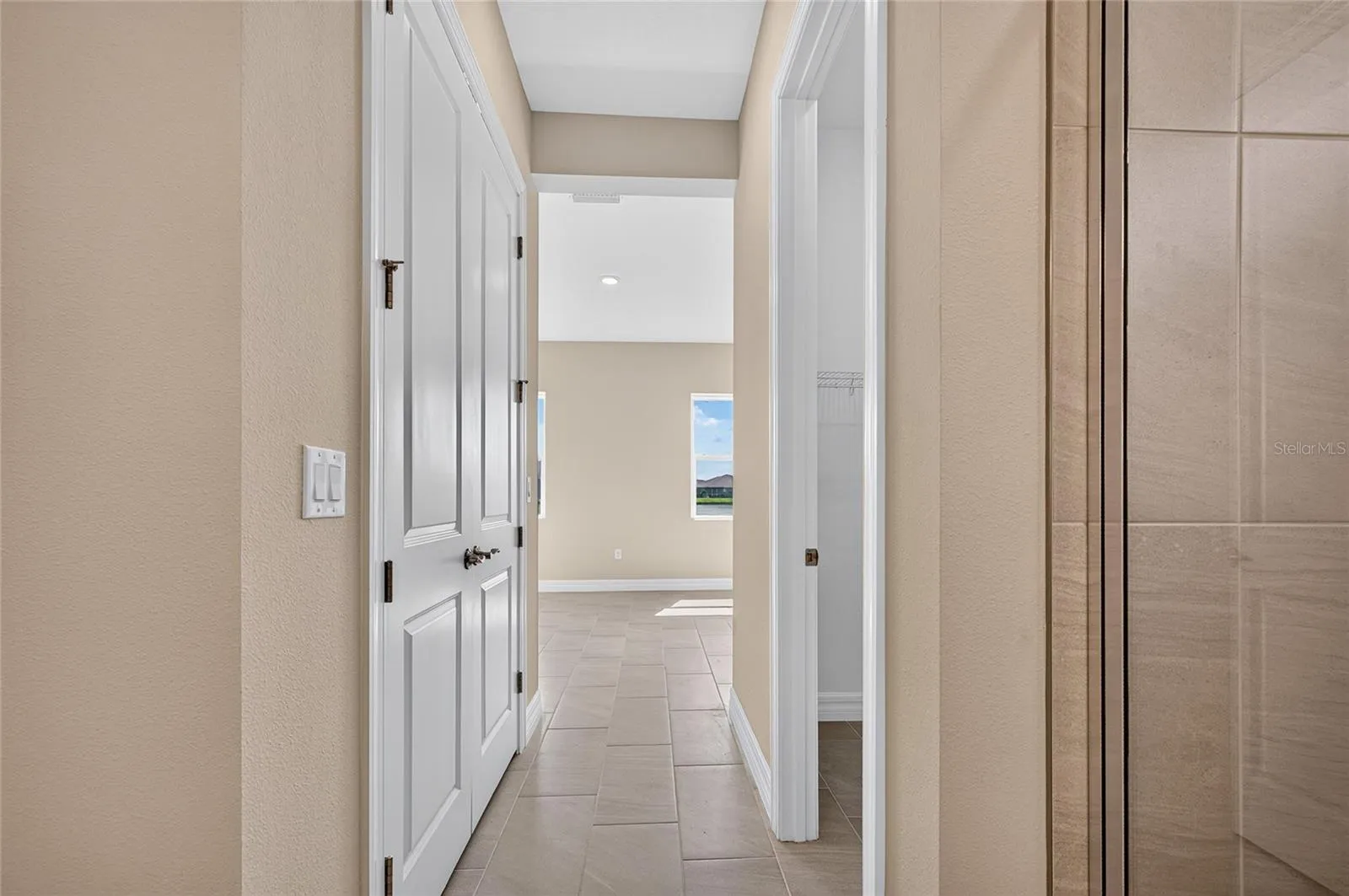 Hallway between primary bedroom into primary bath past duel closets
