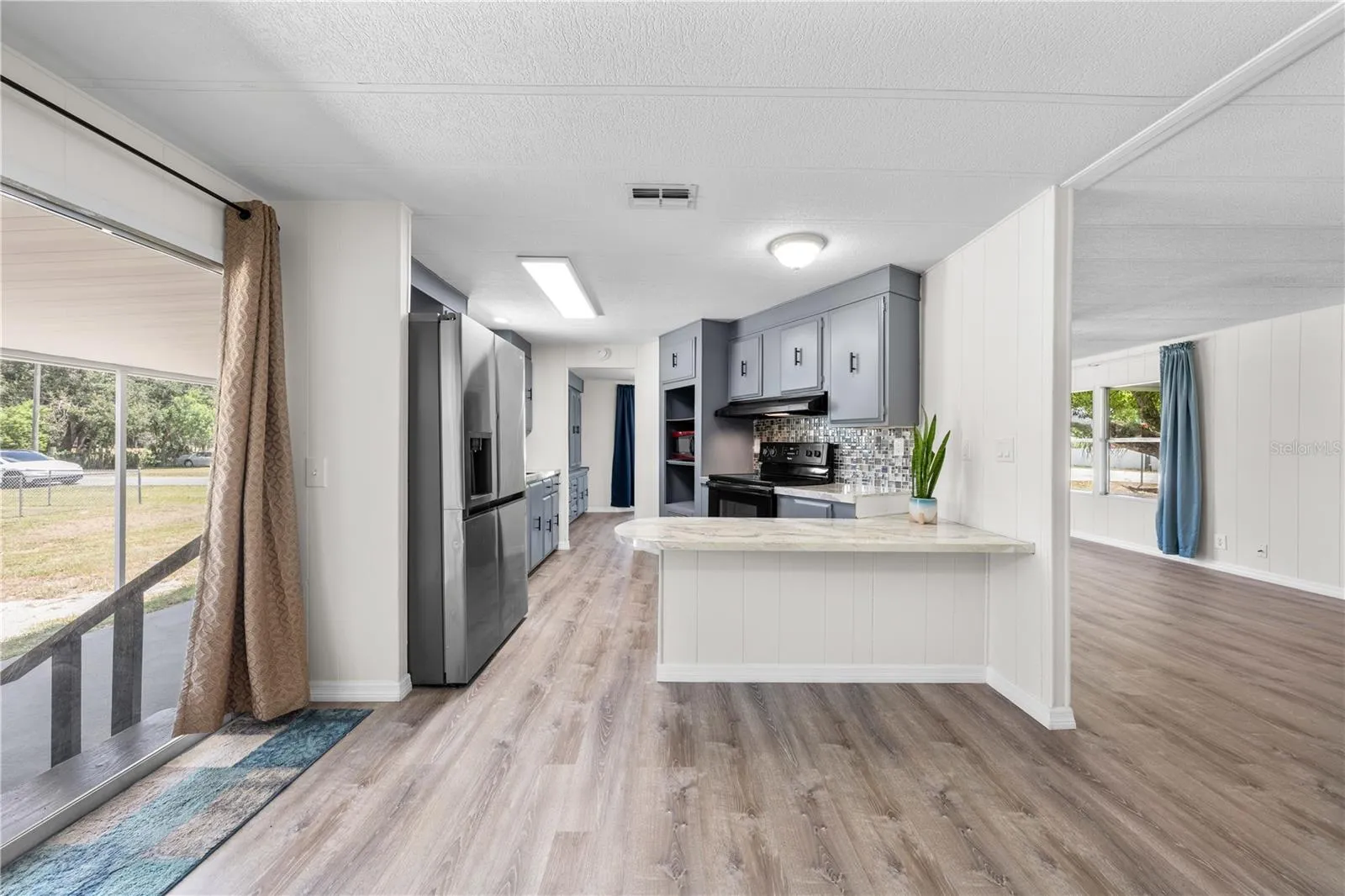 View from flex family room into kichen, dining, living room and outside carport. Don't miss the breakfast bar!