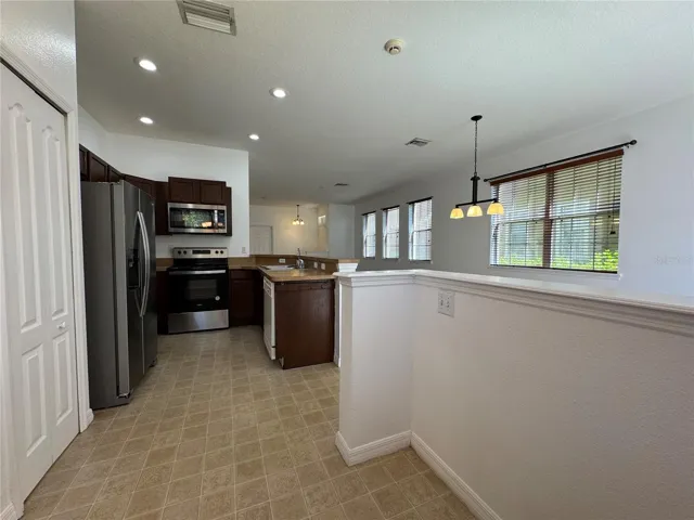 Kitchen includes stainless steel appliances.