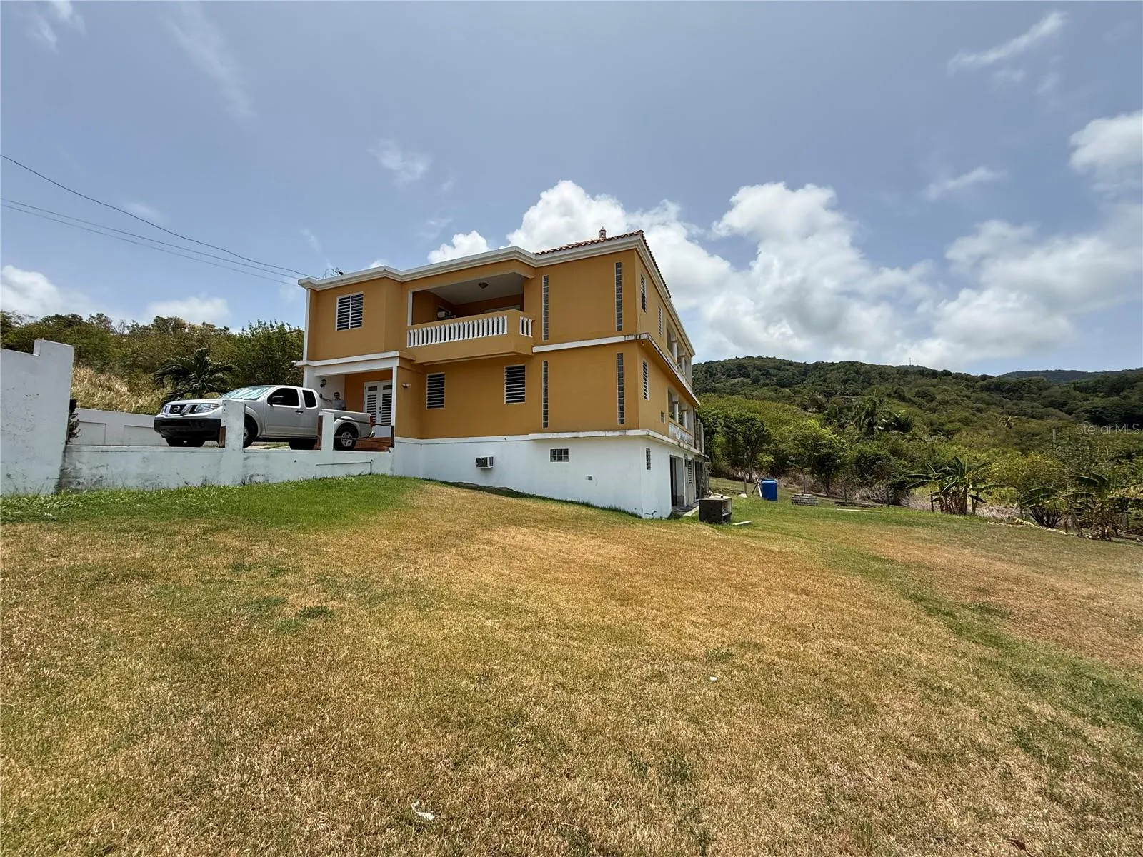 Vista lateral - tres niveles sobre solar elevado / Side view - three levels on an elevated lot