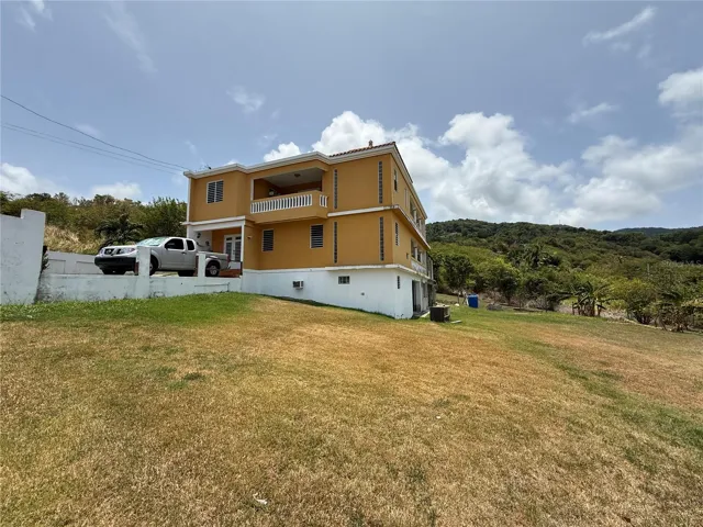 Vista lateral - tres niveles sobre solar elevado / Side view - three levels on an elevated lot