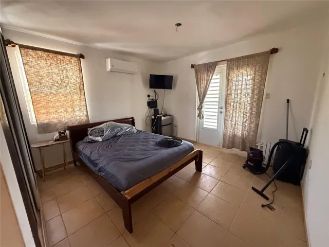 Dormitorio con consola de pared y pisos de losa cerámica / Bedroom with wall A/C and ceramic tile floors