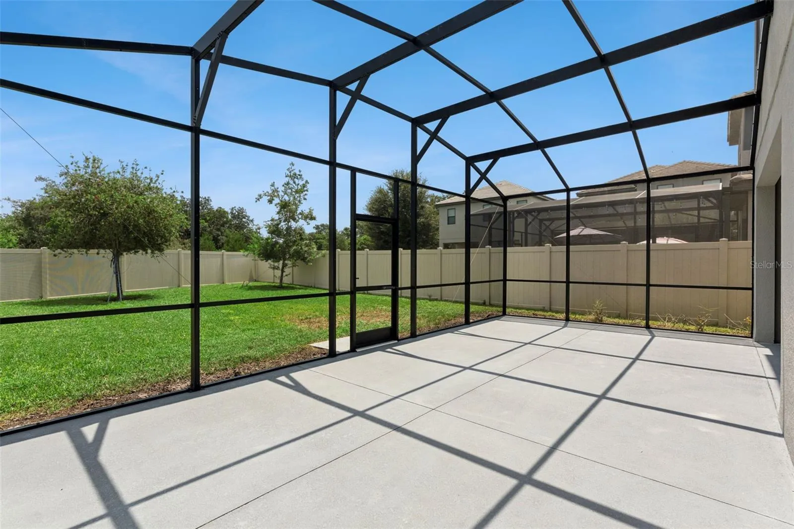 Screened Patio – Expansive screened enclosure extends the home's living space outdoors while overlooking the fenced backyard.