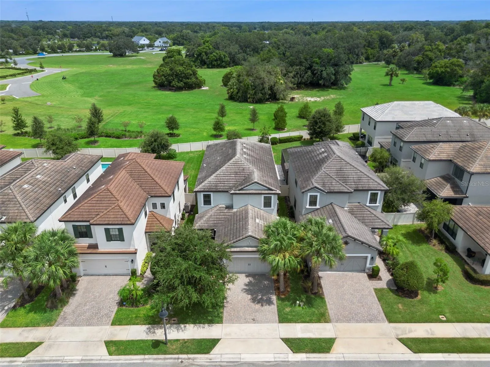 1287 Verdant Glade Pl, showcasing an attractive two-story exterior, paver driveway, and a standout setting with expansive green space directly beyond the backyard.
