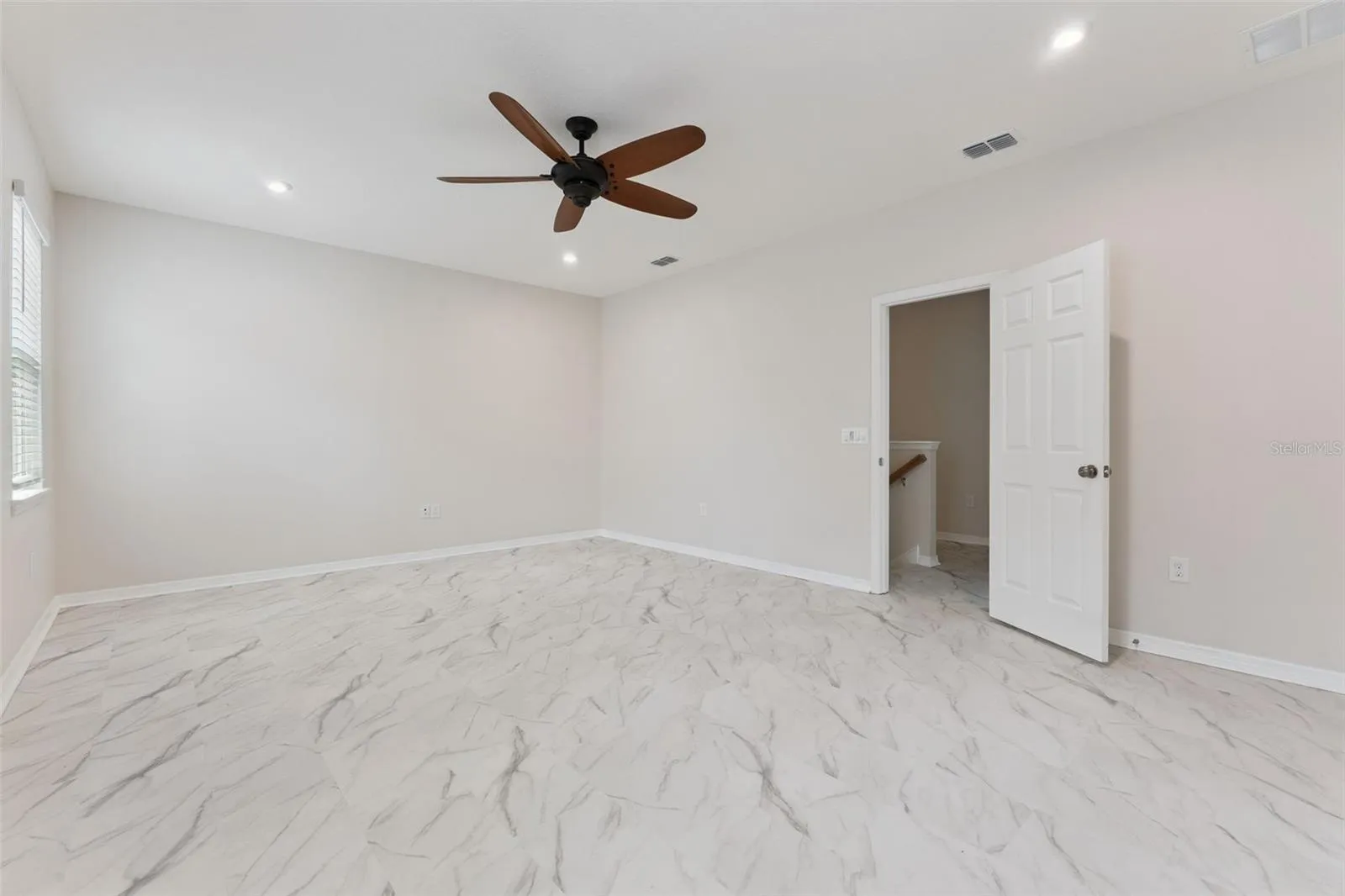 Bonus Room – Spacious enclosed upstairs bonus room with marble-look tile flooring, recessed lighting, and a ceiling fan, offering flexible space for a media room, game room, or home office.