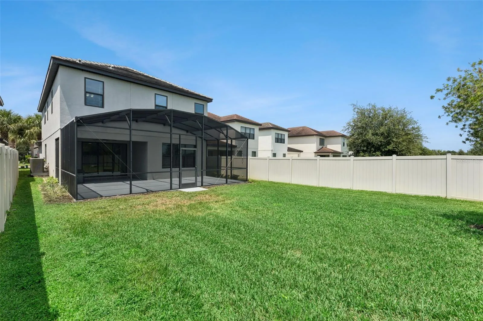 Fenced Backyard – Generously sized fenced backyard provides ample green space alongside the screened outdoor living area.
