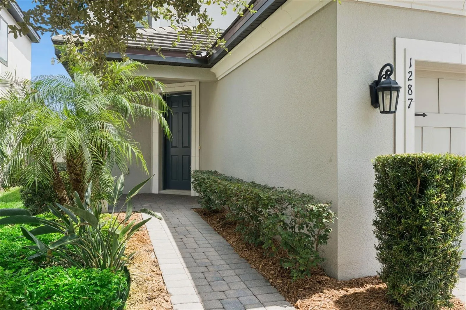 Front Entry – A landscaped paver walkway leads to the covered front entry, creating an inviting approach to the home.