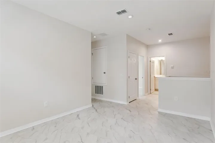 Upstairs Loft – Open upstairs loft provides additional flexible living space with marble-look tile flooring, recessed lighting, and convenient access to the surrounding bedrooms and bath.