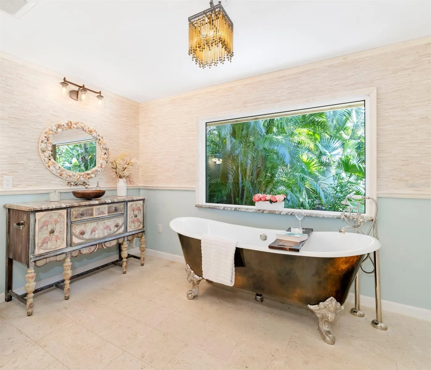 Stunning vanity and clawfoot tub with a view of the lush landscaping