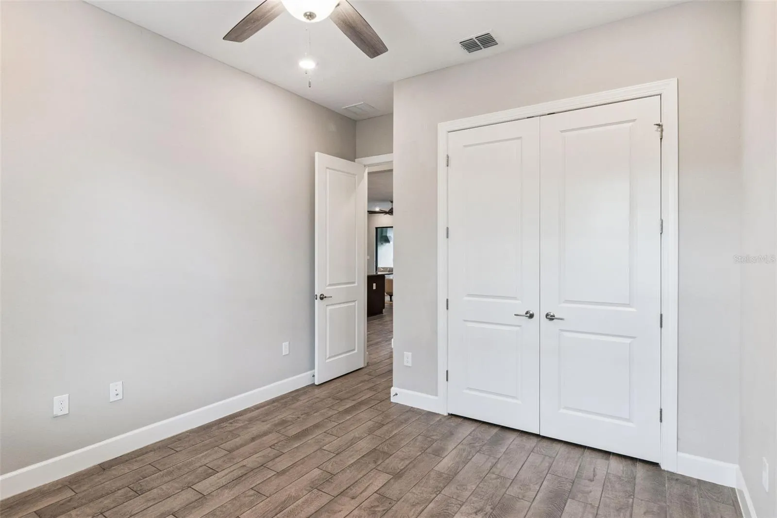 Third bedroom with double door closet and tile flooring.