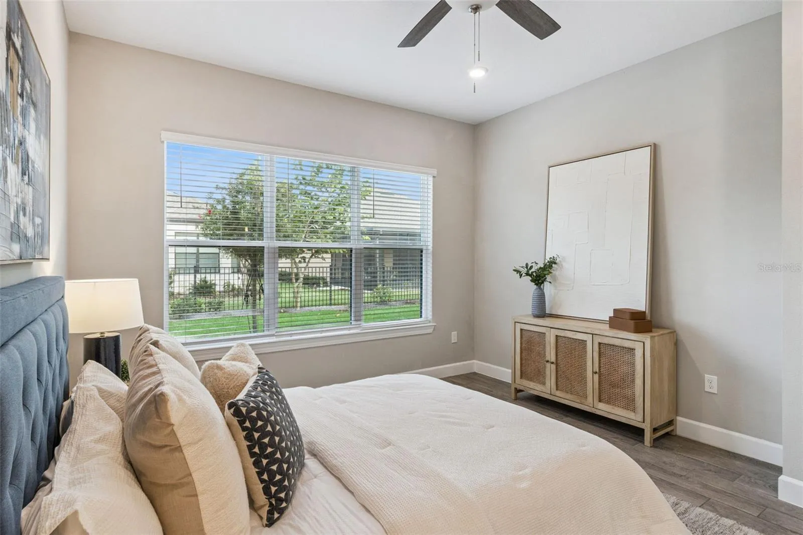 Second primary bedroom with natural light and peaceful neighborhood views.
