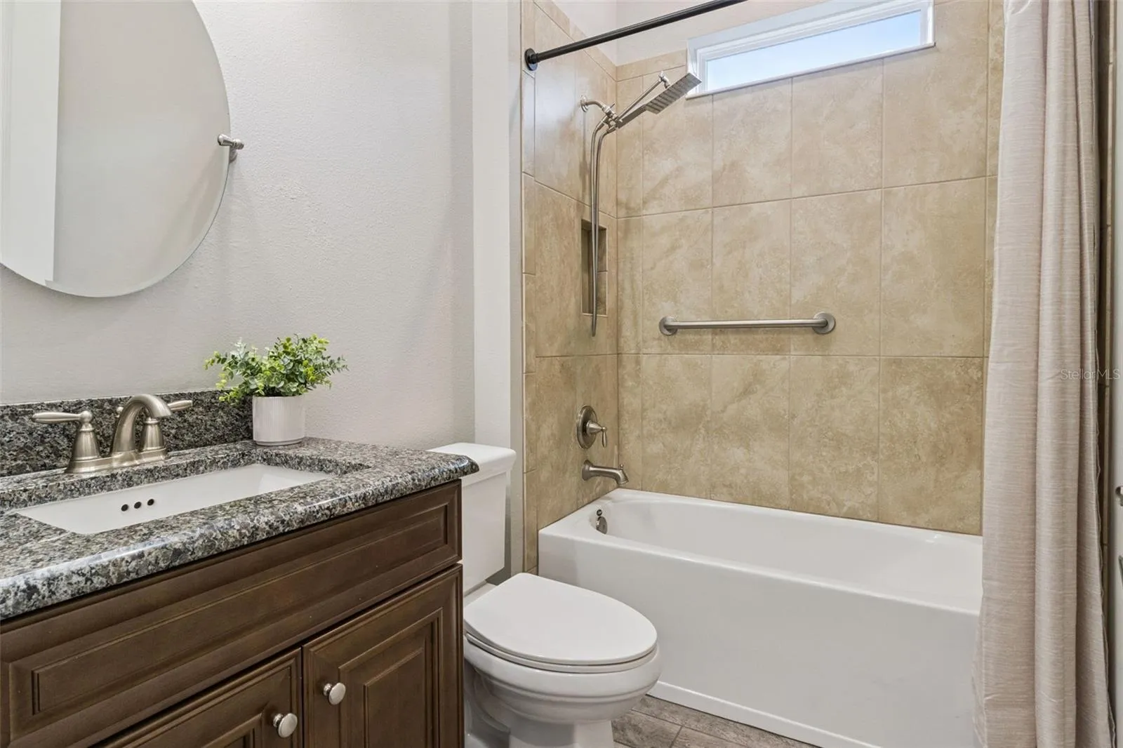 Third full bathroom with tub and shower combination and granite vanity.