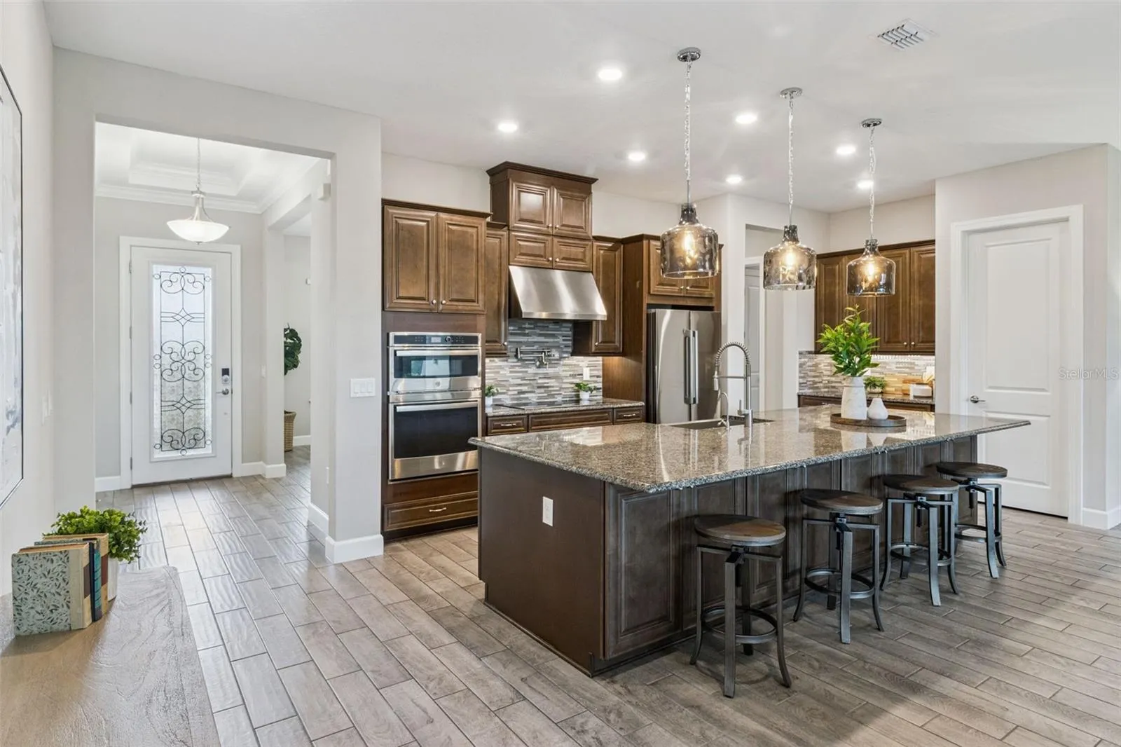 Kitchen with island seating, double wall ovens, and convenient access to the main living areas.