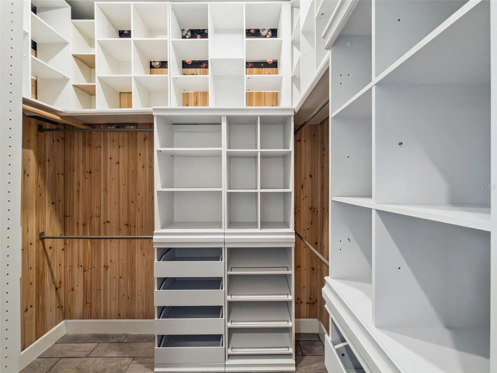 Custom walk in closet with built in shelving and drawers.