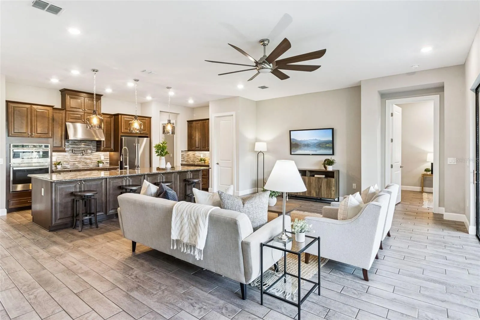 Open floor plan with tile flooring throughout, connecting the great room and kitchen in this Solivita home.