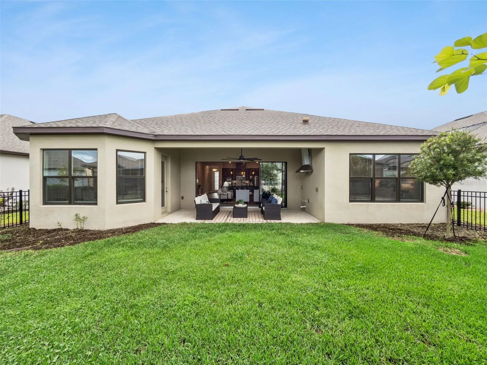 Rear exterior with covered patio and green backyard.