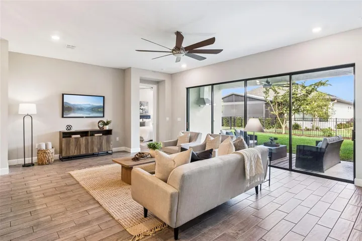 Living room with sliding glass doors and relaxing backyard views in Solivita, Poinciana.
