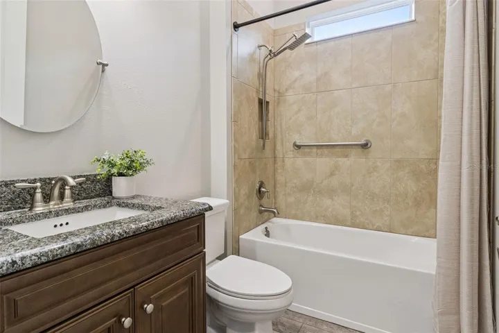 Third full bathroom with tub and shower combination and granite vanity.