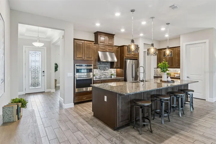 Kitchen with island seating, double wall ovens, and convenient access to the main living areas.