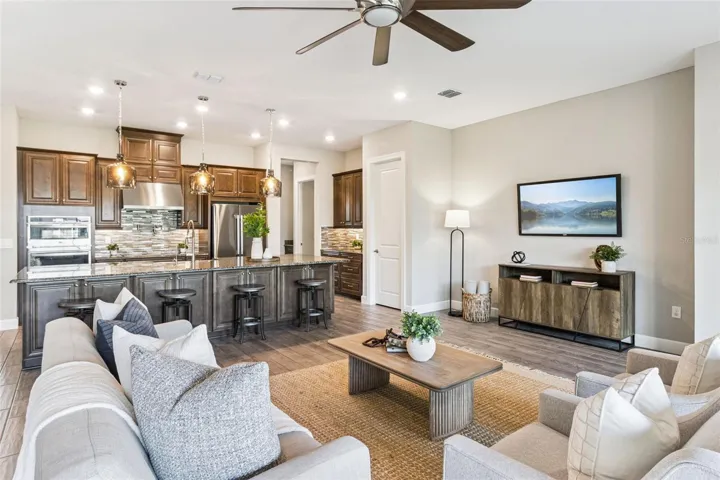 Open great room layout connecting the kitchen, living, and dining spaces.