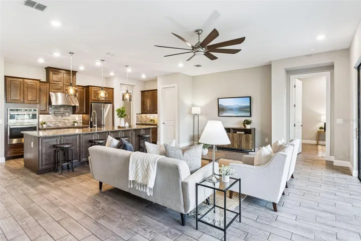 Open floor plan with tile flooring throughout, connecting the great room and kitchen in this Solivita home.