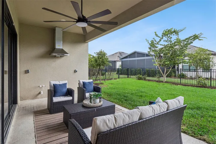 Private fenced patio with ceiling fans, perfect for relaxing or entertaining.