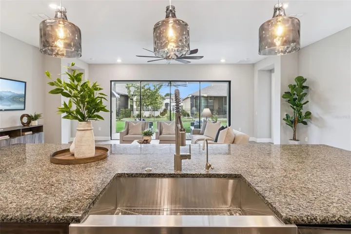 View from the kitchen sink across granite counters to the living area and covered patio.