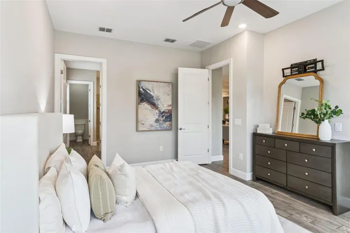 First primary bedroom with dresser area, ceiling fan, and generous space.