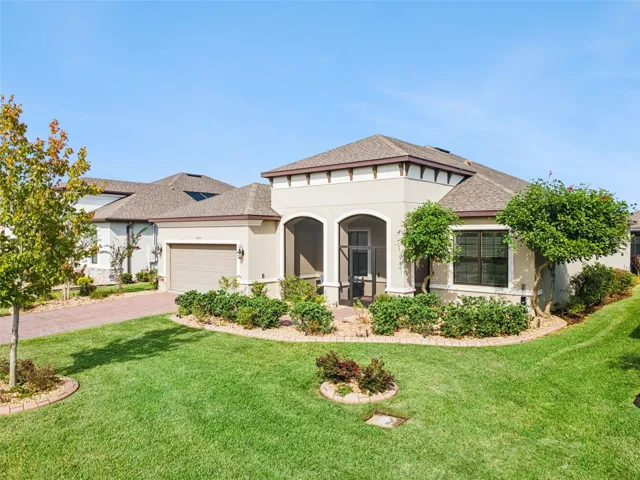 Front exterior with tile roof, arched windows, and manicured lawn in Solivita.