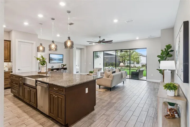 Kitchen island with pendant lighting and ample workspace overlooking the family room and patio.