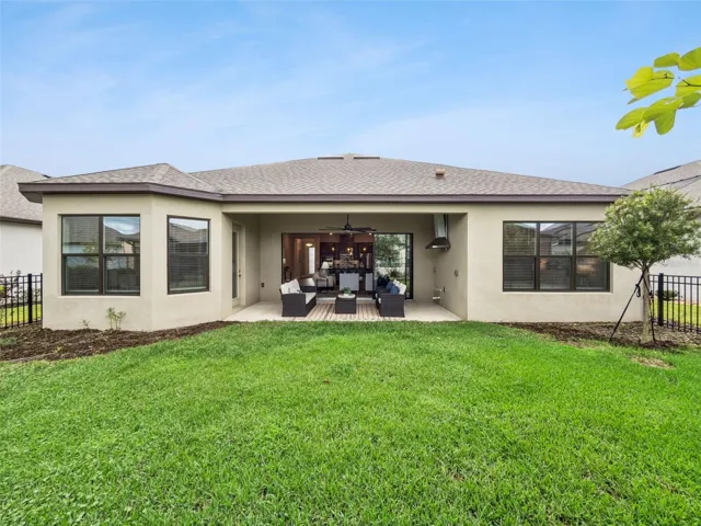 Rear exterior with covered patio and green backyard.