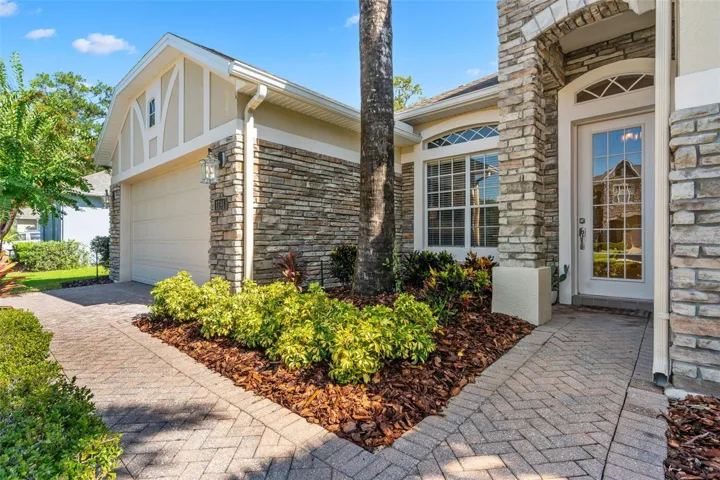 FRESH LANDSCAPING (2026), STONE-FACED ACCENTS and a BRICK-PAVER walkway lead to the beautiful GLASS-PANELED FRONT DOOR.