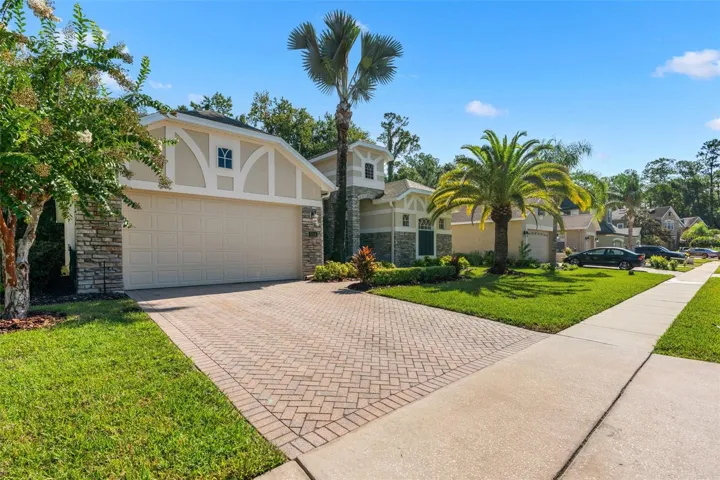 A BRICK-PAVER DRIVEWAY leads to the 2-CAR GARAGE that includes overhead storage.